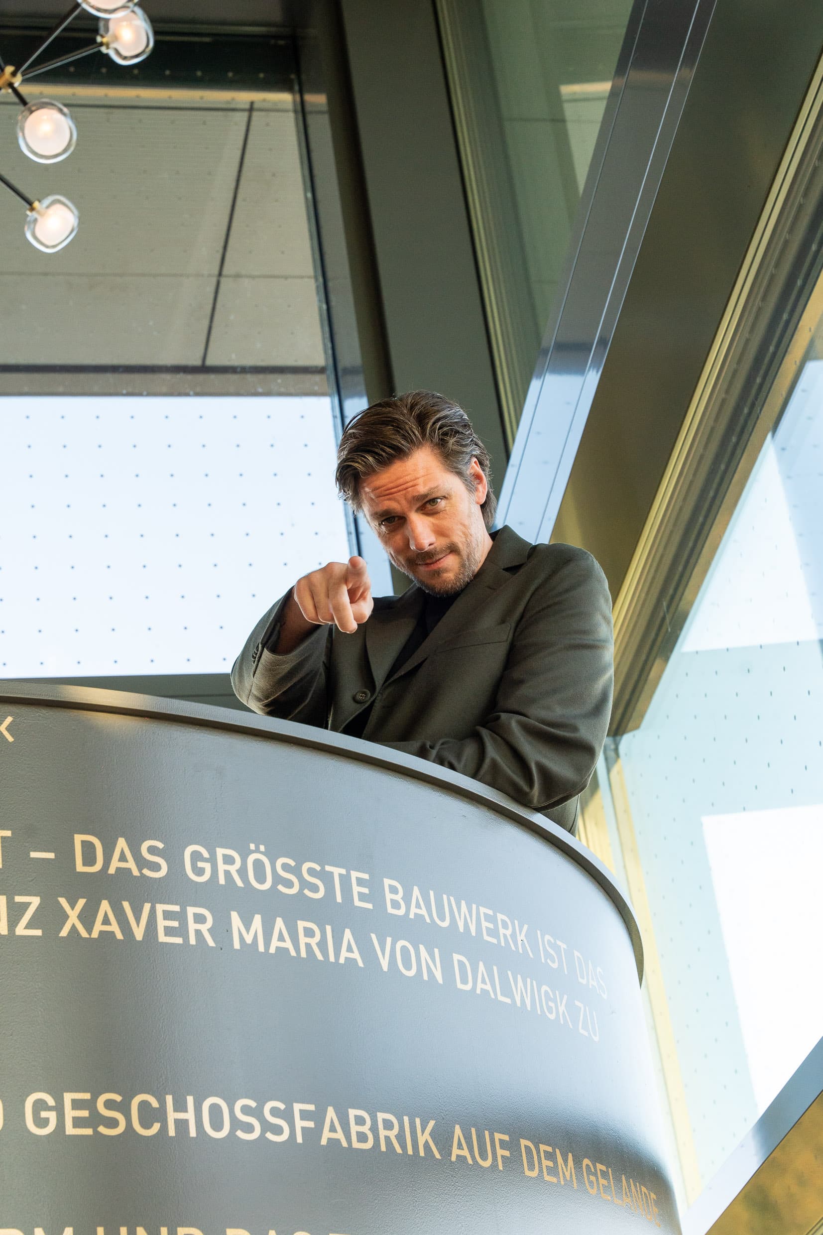 Der Geschäftsführer des Dalwigk zeigt von der Galerie aus direkt in die Kamera.